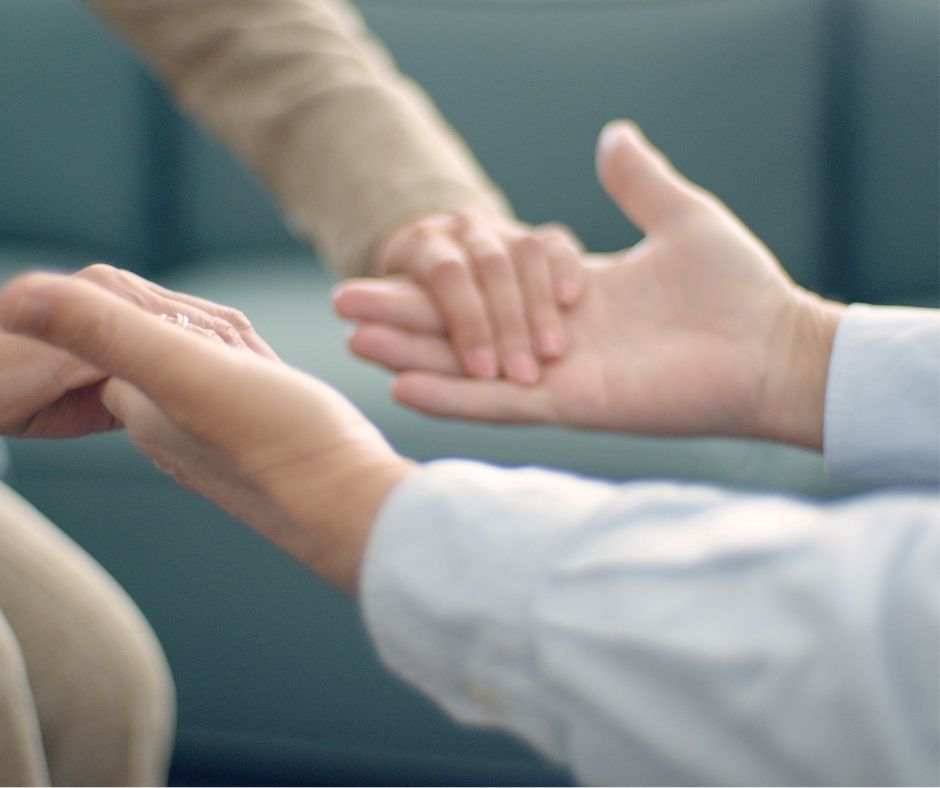 psychologist holds the hands of their client - mental health