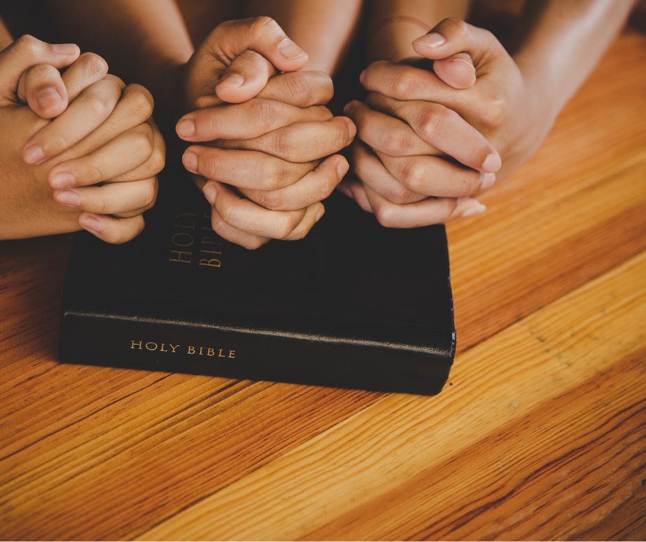 fellowship for mental health - multiple hands in prayer over a bible
